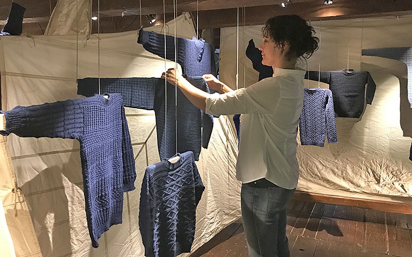 Annelies Verbrugge hangt de truien in de tentoonstelling