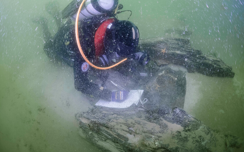 Duiker doet onderzoek bij een scheepswrak onder water